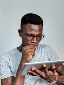 man with glasses looking at a tablet 